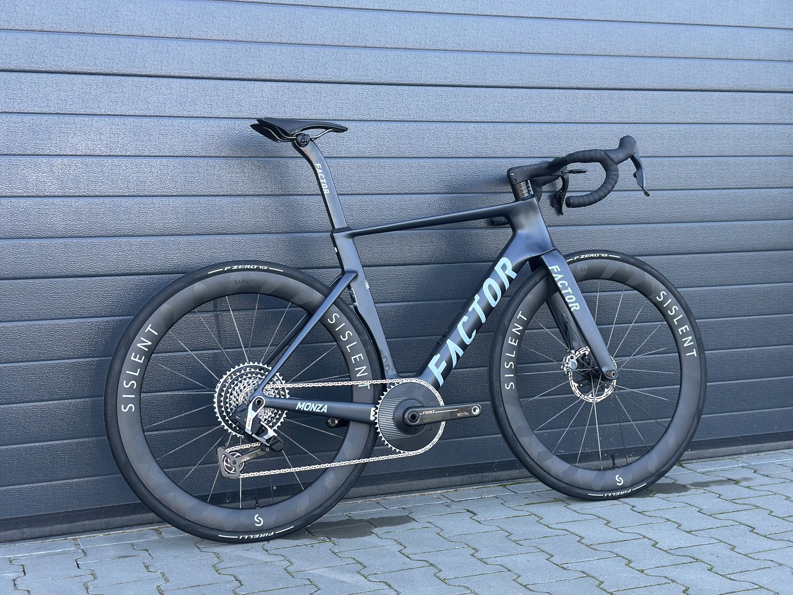 Factor Monza 54 w ciemnym lakierze z grupą SRAM Red E1 XPLR i kołami Sislent Rapid LC 55, widok z boku